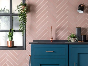 Pink subway tiles on a kitchen wall in herringbone style