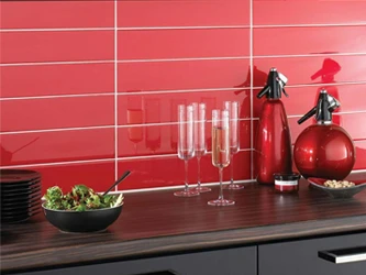 Red subway tiles in 100x300mm (10x30cm) tiled on a kitchen splash back, these tiles are a high gloss finish.