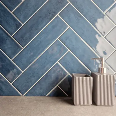 nebula blue ceramic wall tile on a splash back in herringbone style, bumpy gloss finish.