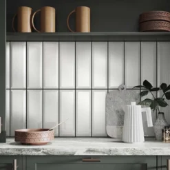 Metro gloss white bevelled wall tile in 100x300mm on a kitchen splash back with a Carrara work top.